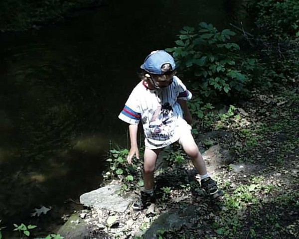 5 year old diaper boy outside playing in diaper and shirt