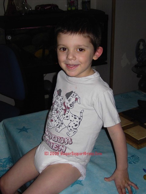 5 year old boy wearing plastic backed diapers and sucking on pacifier.