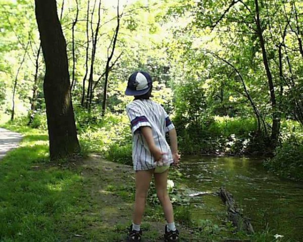 8 year old diaper boy outside playing in diaper and shirt