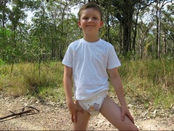 Older kid boy 8 year old boy wearing huggies diapers and shirt outside