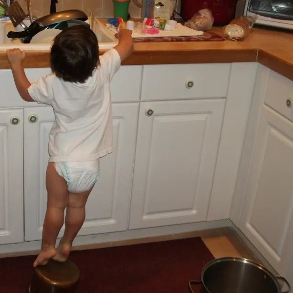 3 year old boy diaper climbing up on counter wearing pampers and shirt