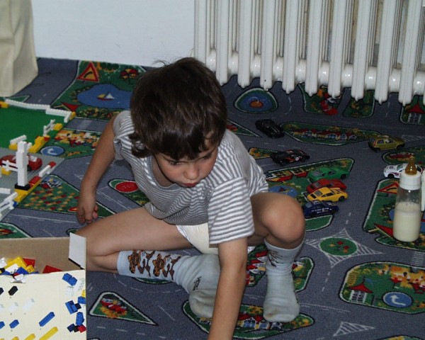 Wet Diaper Tommy sitting on floor playing toys in diaper